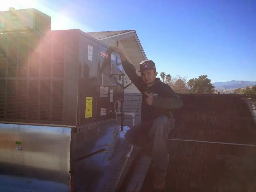 HVAC technician performing Air Duct Repair on a rooftop unit in Johnson Lane